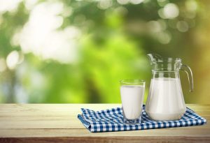 Photo of fluid milk in a pitcher with glass on picnic table. Dairy is Pennsylvania's number one agricultural commodity.