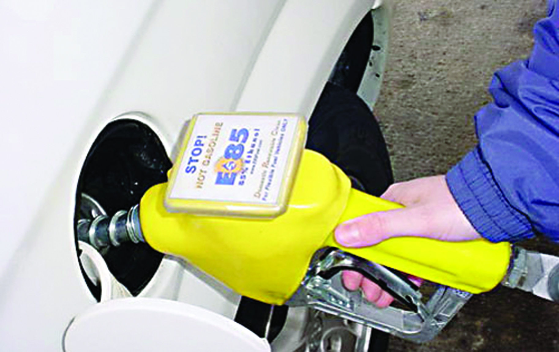 person pumping E85 fuel with yellow handle into white car