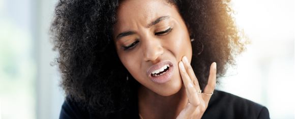 December wellness - Girl holding jaw with tooth pain